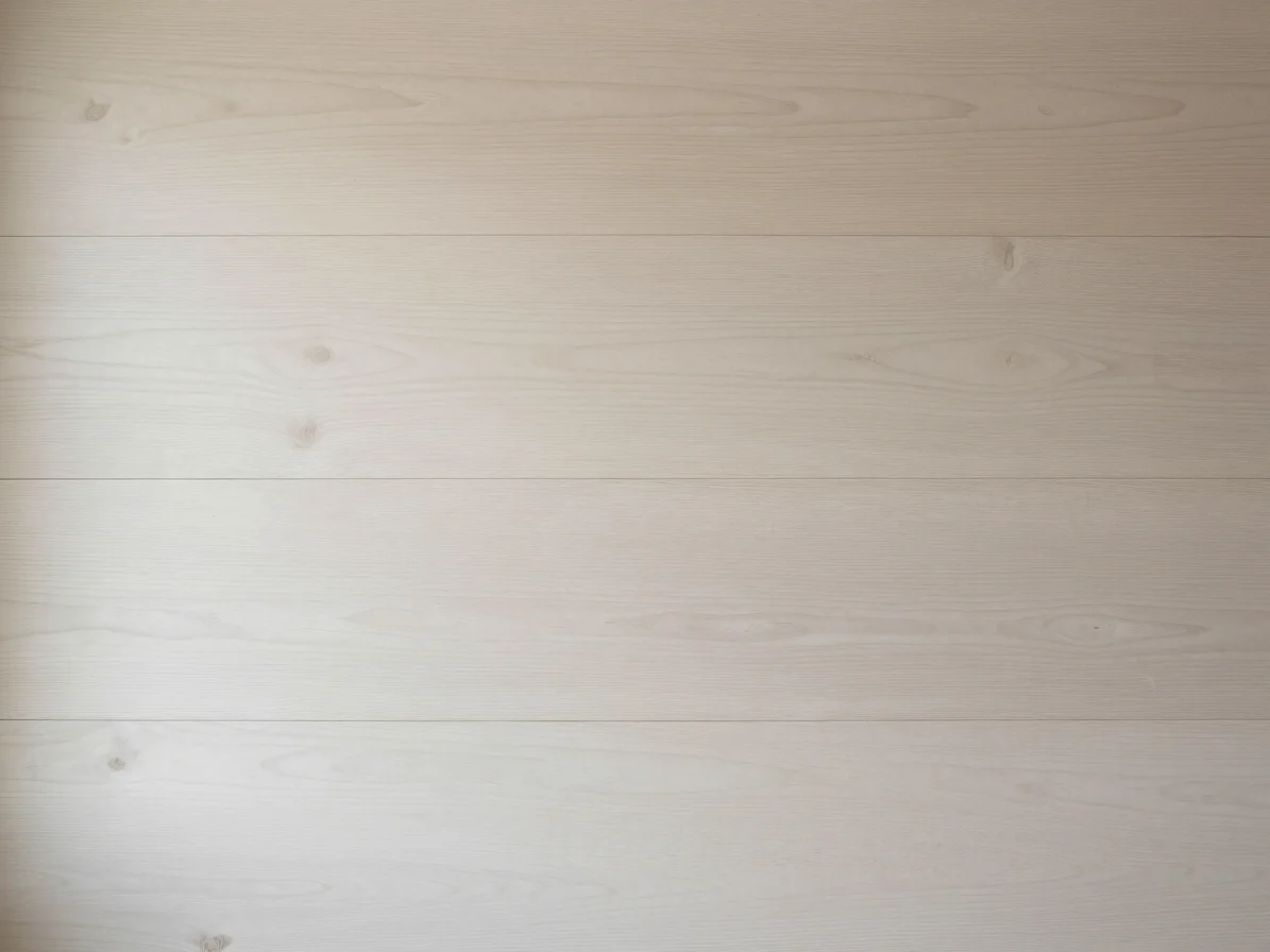 Close photograph of pale ash and beech wood surfaces side by side, soft natural light, beige and off-white tones, minima